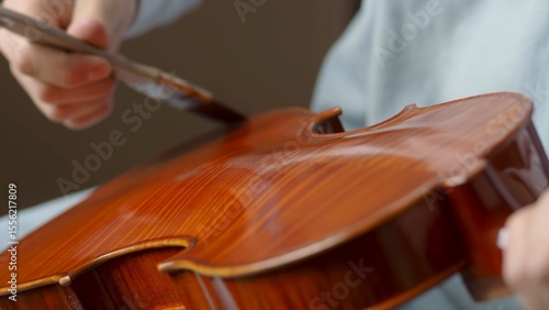 Obraz na plátně Skilled craftsman applying protective varnish to violin body, highlighting intri