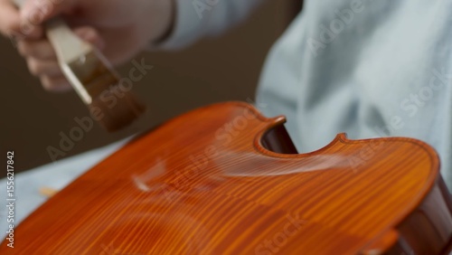 Obraz na plátně Skilled craftsman applying protective varnish to violin body, highlighting intri