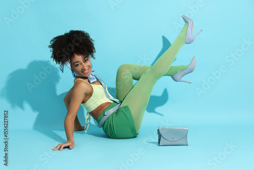 Quadro su tela Fashionable portrait of beautiful Brazilian woman in stylish outfit on light blu