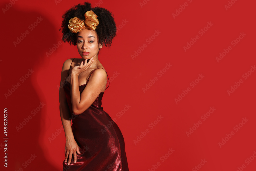 Fototapeta premium Fashionable portrait of beautiful Brazilian woman in stylish outfit on red background. Space for text