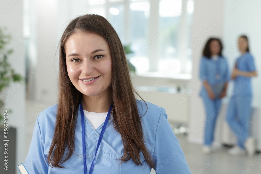 Medical student in uniform with notebook indoors, selective focus Medical student in uniform with notebook indoors, selective focus