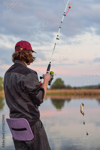 An angler is fishing on the lake