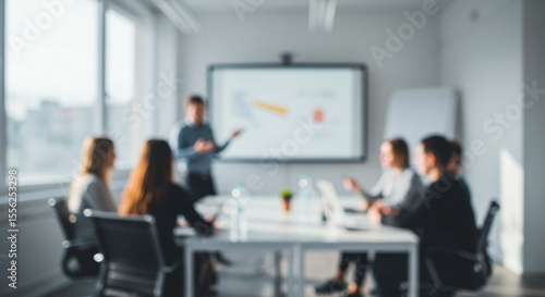 Business meeting with people around a table looking at a presentation screen.