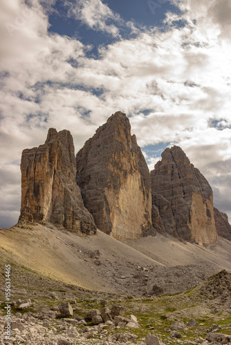 Wallpaper Mural Iconic mountain peaks known as the Tre Cime di Lavaredo rise above a rocky valley in the Italian Alps. Dramatic clouds and rugged terrain evoke a sense of wilderness and grandeur. Torontodigital.ca