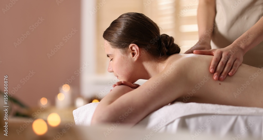 Obraz premium Woman receiving back massage with oil in spa salon, space for text