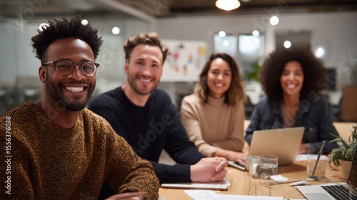 Diverse team of colleagues in stylish business casual wear collaborating around a conference table, candid interaction, inclusive setting