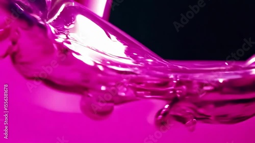 Magenta liquid creates dynamic splash formations with flowing waves and droplets against dark background showcasing fluid motion and vibrant pink purple color intensity