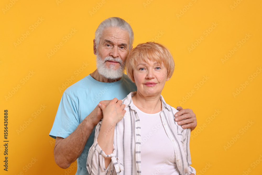 Portrait of lovely senior couple on orange background Portrait of lovely senior couple on orange background
