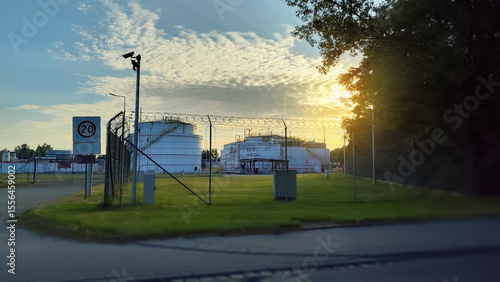 Industrial territory of oil storing petroleum products surrounded by a high-security fence and surveillance cameras.