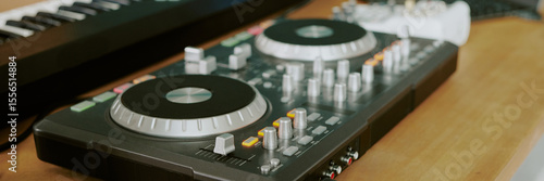 Billede på lærred Closeup showing DJ controller and electronic keyboard on wooden table, music pro