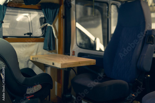 Cozy interior of a camper van with wooden table and comfortable seating in the Alps