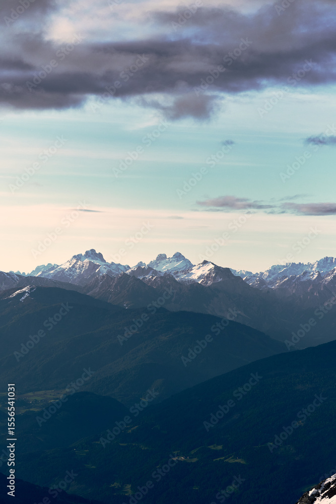Fototapeta premium Majestic alpine mountains under a dramatic sky at dusk, showcasing the rugged beauty of the landscape