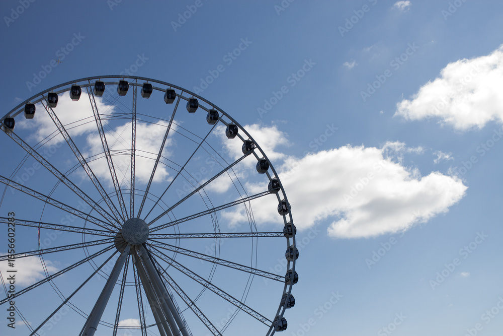 Fototapeta premium ferris wheel with clouds and blue sky