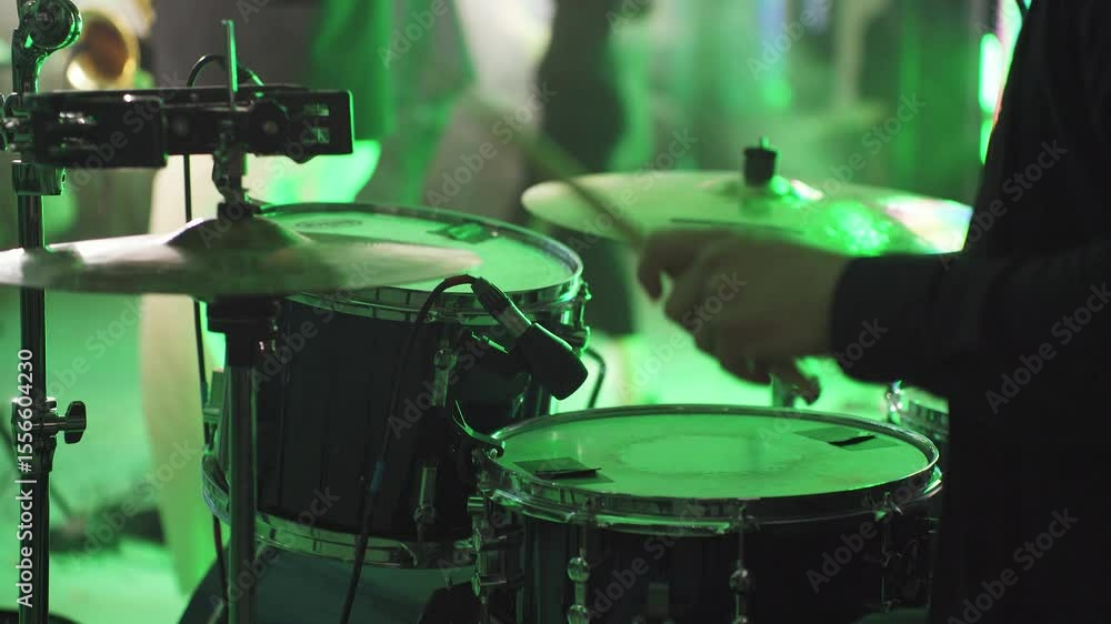 Close-up of hands of drummer, musician playing drums, hitting cymbals, drums with drumsticks. Drummer sets tempo of musical composition, performance of rock band, cover band, music festival, party.