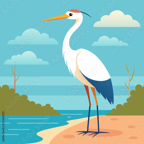 A white heron stands on a sandy shore next to a calm blue lake