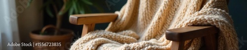 Cozy oversized sweater blanket draped on a rustic wooden chair, soft texture and neutral tones, perfect for chilly evenings , soft, snuggle, cream