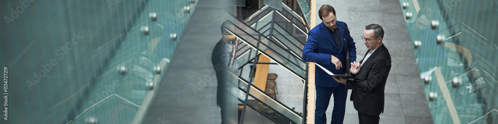 Ταπετσαρία Header of two businessmen in formal attire conversing in modern office corridor