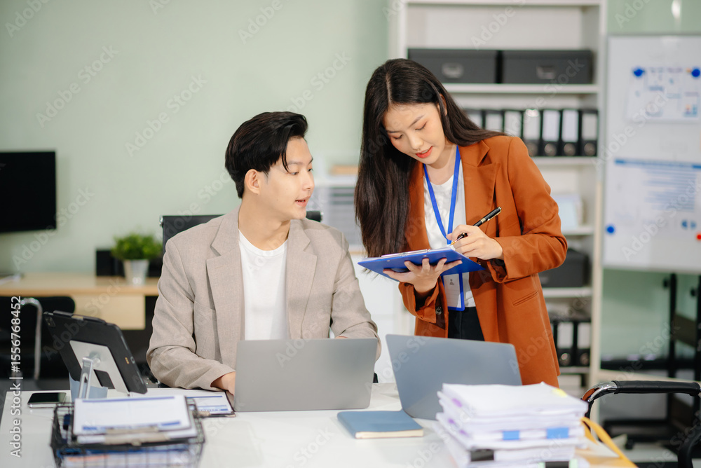 Obraz premium Two business workers talking on the smartphone and using laptop