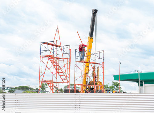 Workers are setting up scaffolding for the construction of the metal sheet tank.