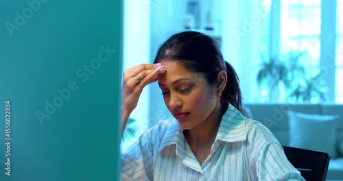 Indian businesswoman having headache while working on laptop at desk in modern cozy office, Asian young female showing stress and stiff neck symptoms while dealing with workload and physical pressure