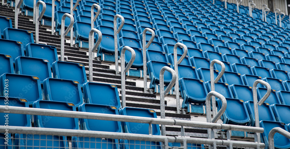 Naklejka premium multiple row of blue reserved empty chair, seat in stadium for soccer, football sport game and festival or concert in lined up in a row for audience