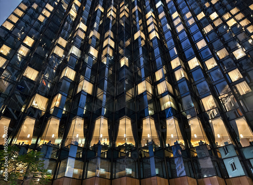 Foto A tall building with many windows is beautifully lit up at night