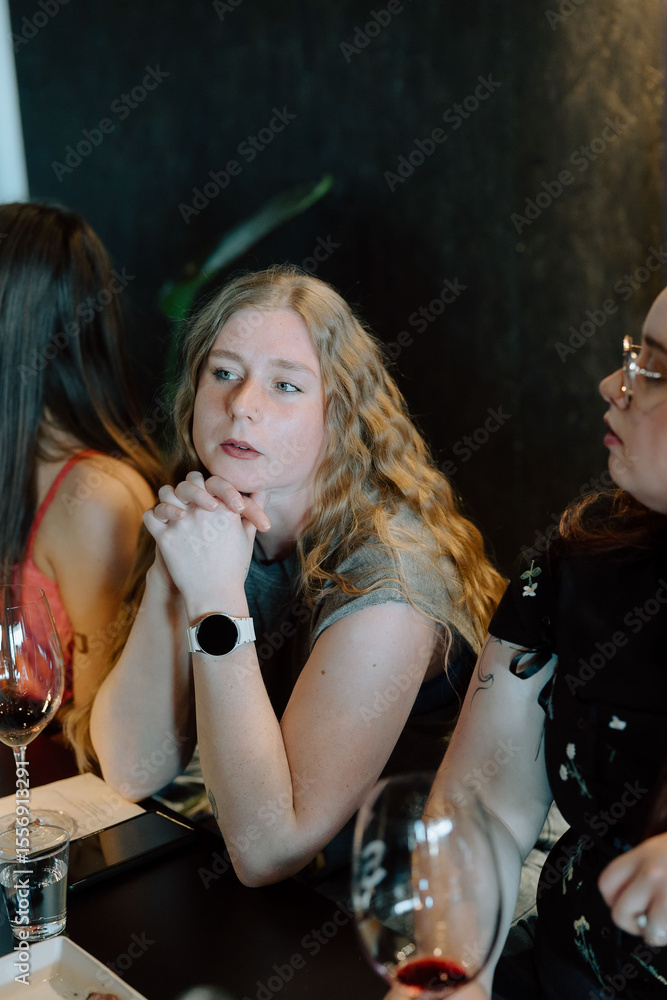 Fototapeta premium Woman listens closely with hands clasped under her chin