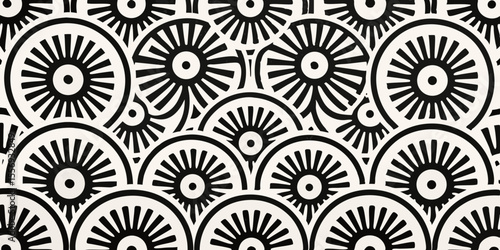 Black and white graphic pattern of repeating sunburst or wheel motifs