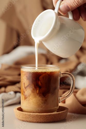 Pouring cream in black coffee.