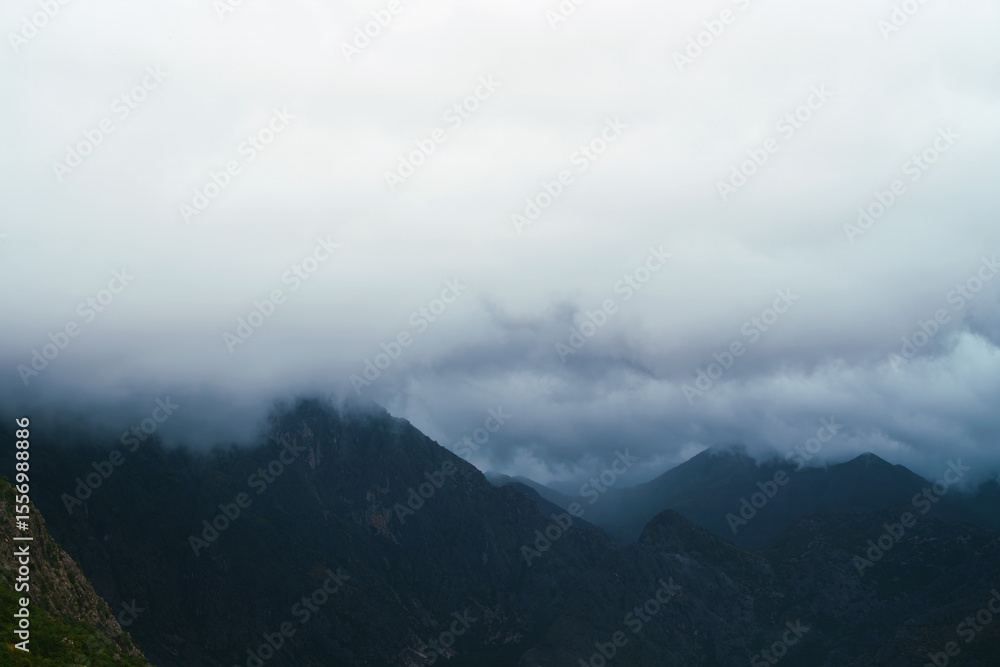 Obraz premium Misty haze envelops the mountain peaks