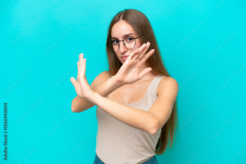Fototapeta premium Young caucasian woman isolated on blue background nervous stretching hands to the front