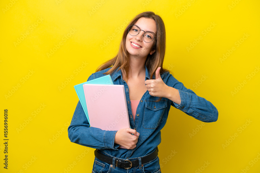 Young student caucasian woman isolated on yellow background giving a thumbs up gesture Young student caucasian woman isolated on yellow background giving a thumbs up gesture