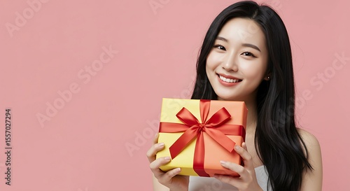 Happy Woman Holding a Gift Box on Pink Background