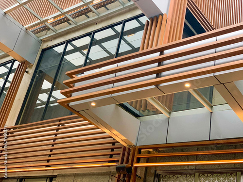 Modern architectural interior with wood and metal panel design, featuring geometric lines, glass, and lighting. Contemporary structure with clean aesthetic and industrial style.