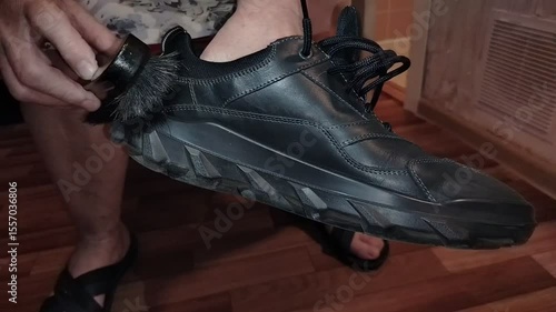 Woman at home cleaning spring boots with a dark brush