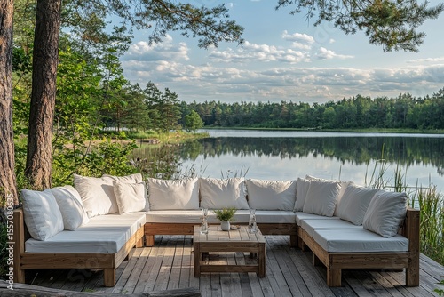 Outdoor garden corner sofa set with white cushions, white, grey and wood frame, coffee table, placed in front of a lake