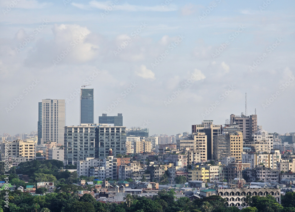 Obraz premium Dhaka city skyline with modern buildings and clear blue sky, urban architecture and cityscape view of Bangladesh capital. High angle view of Dhaka city residential and financial buildings at sunny day