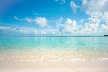 Beautiful summer sandy beach with white sand and calm wave of turquoise ocean on sunny day. Background for rest and travel.
