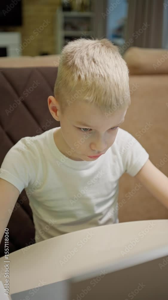 A boy with hearing aids engages with a laptop and tablet, showcasing modern childhood's digital learning and inclusive tech play. Perfect for education and disability awareness content A boy with hearing aids engages with a laptop and tablet, showcasing modern childhood's digital learning and inclusive tech play. Perfect for education and disability awareness content