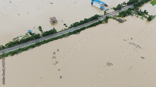 High-angle drone view of storm flooding near a state highway, showing widespread water damage to infrastructure and land.
