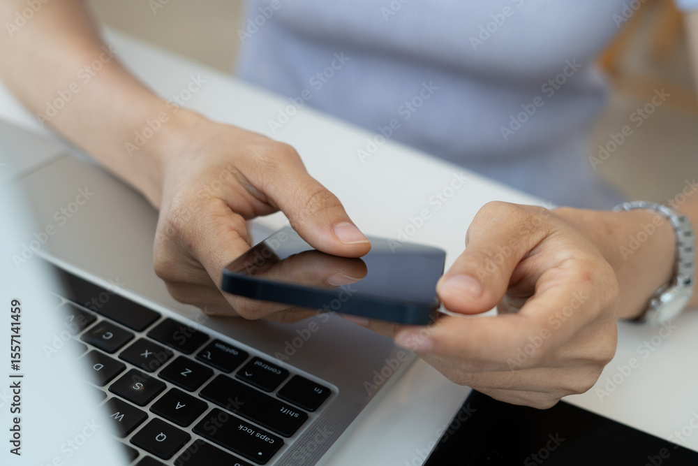 Woman using mobile smartphone, finger touching on screen with laptop computer and digital tablet on office table, closeup. Woman using mobile smartphone, finger touching on screen with laptop computer and digital tablet on office table, closeup.