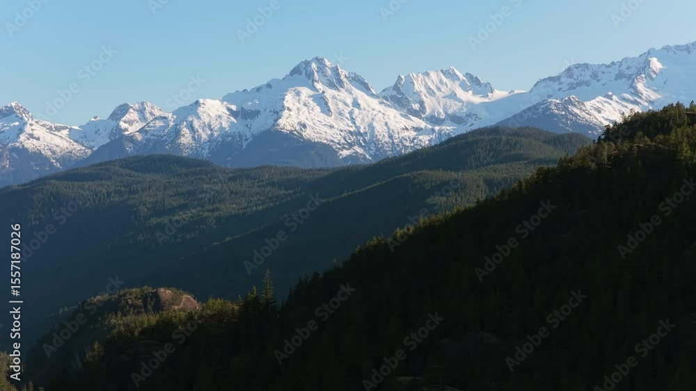 Majestic Snow-Capped Mountains and Lush Evergreen Forests in British Columbia, Canada on a Clear Day Majestic Snow-Capped Mountains and Lush Evergreen Forests in British Columbia, Canada on a Clear Day