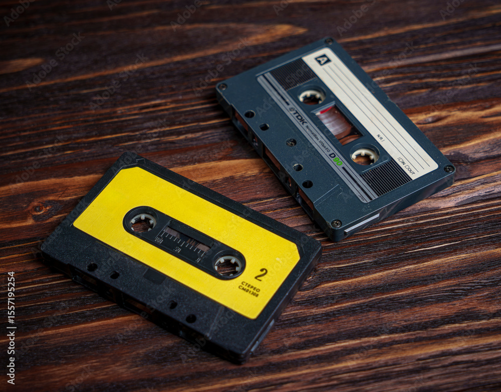 Obraz premium Two vintage audio cassette tapes on dark wooden surface