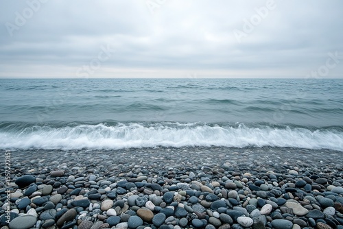 Great Lakes shoreline pebbles: wave foam traces under overcast sky minimalist composition for design textures, geology details