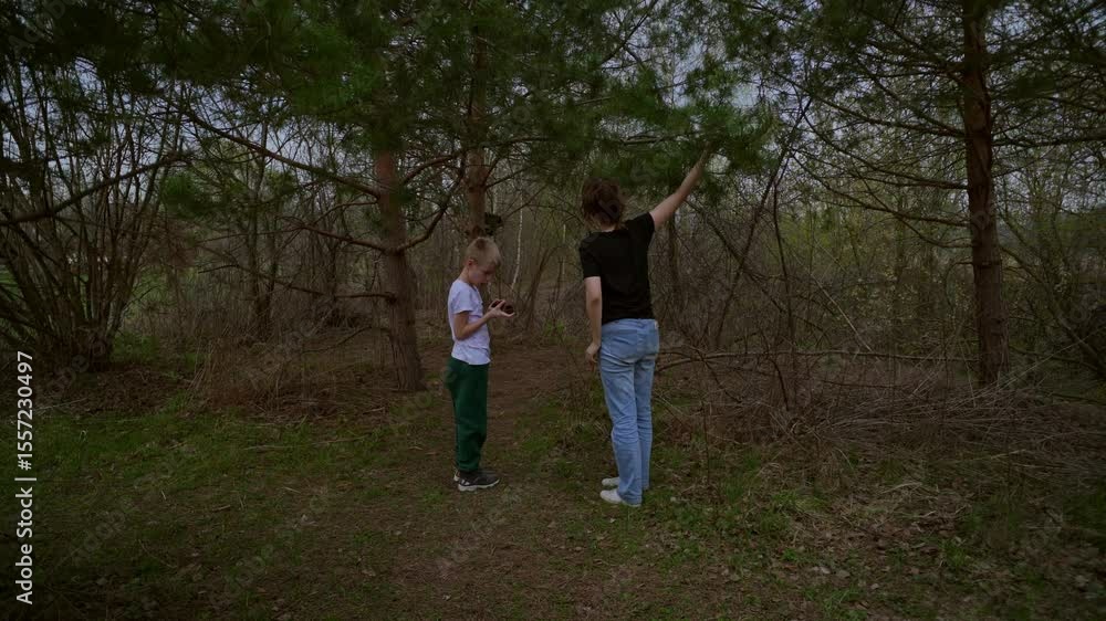 mother and her son with a hearing aid enjoy a peaceful forest walk, sharing a genuine moment of connection and rehabilitation in nature. Authentic, heartwarming family bonding mother and her son with a hearing aid enjoy a peaceful forest walk, sharing a genuine moment of connection and rehabilitation in nature. Authentic, heartwarming family bonding
