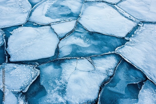 Ontario lake ice melt patterns: geometric cracks, blue-white textures for climate change visuals, abstract nature photography