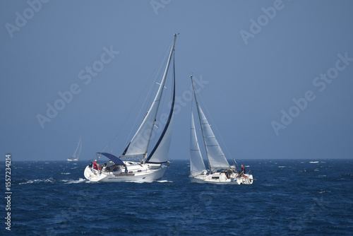 Sailing Adventure on a Clear Blue Sea: Two Yachts Compete in a Regatta