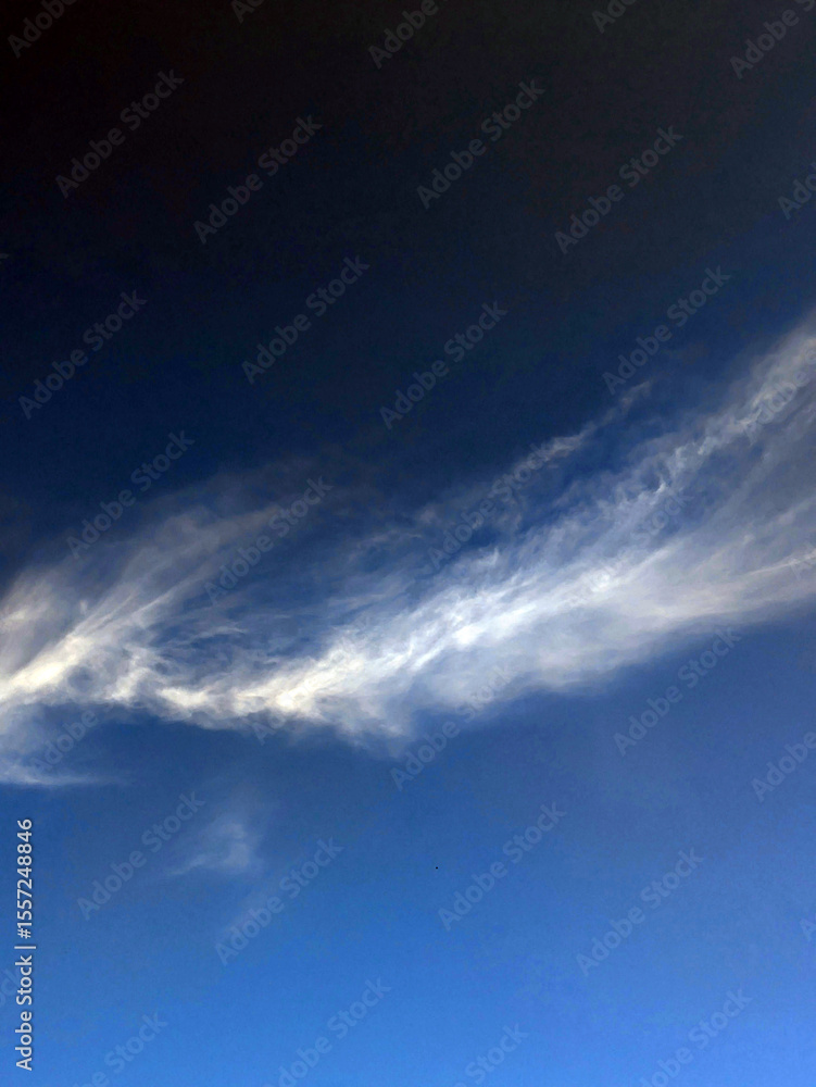 Obraz premium Close up of atmospheric blue black sky with whispy white clouds