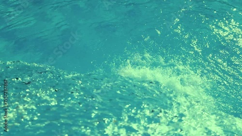 Slow motion video of green clear water falling into a swimming pool