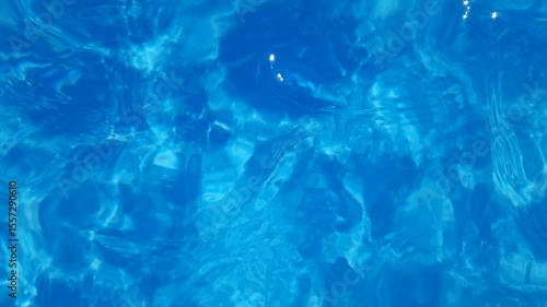 Background blue water movement with top view close up in swimming pool. Slow motion video.